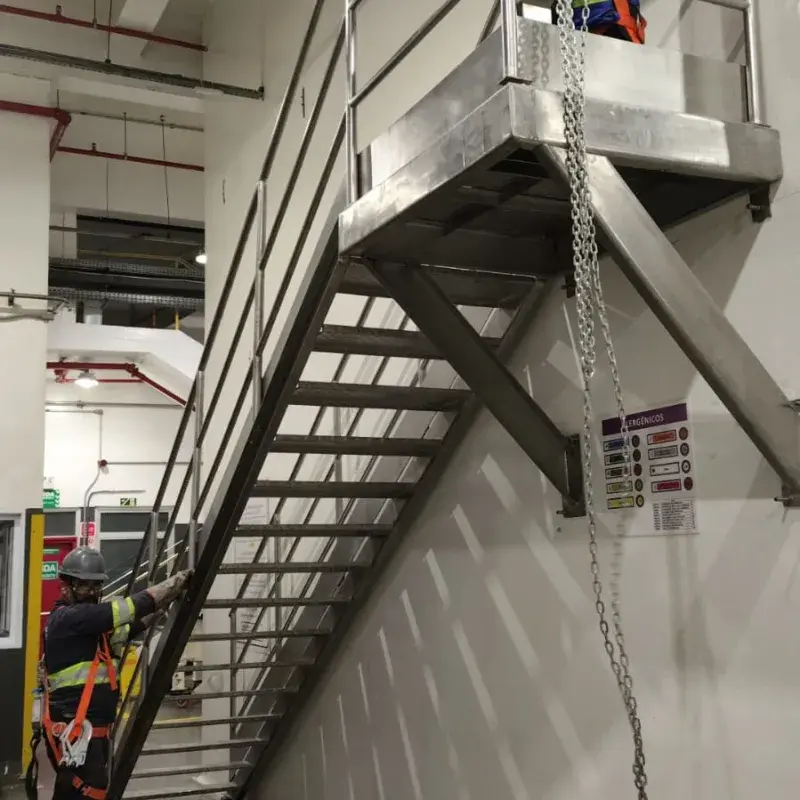 Equipe MetalPev em ação: técnicos com EPI instalando escada e plataforma em aço inox