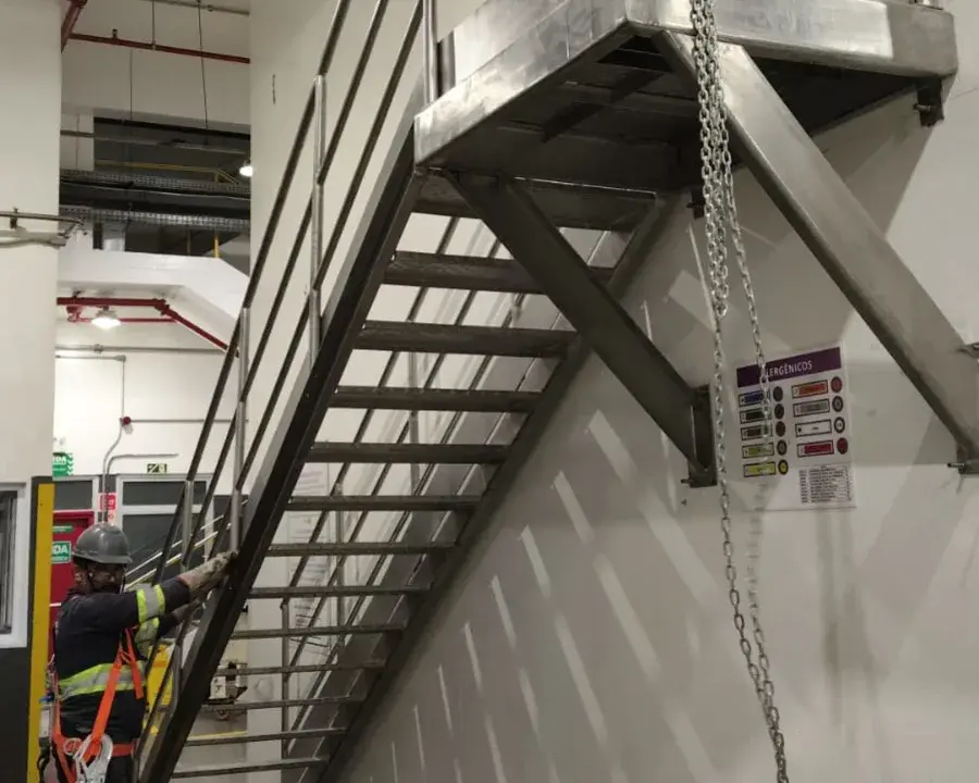 Equipe MetalPev em ação: técnicos com EPI instalando escada e plataforma em aço inox
